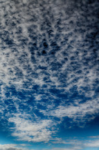 choppy white clouds in a blue sky
