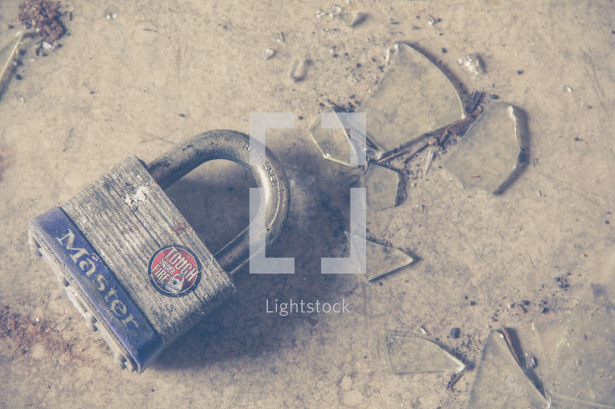 a padlock and broken glass on a floor 