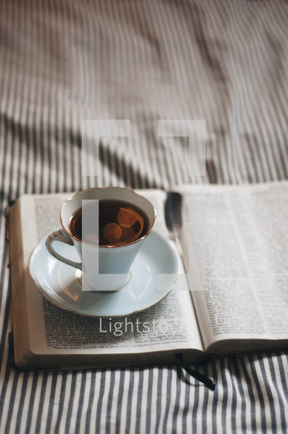 coffee cup and saucer on the pages of a Bible 