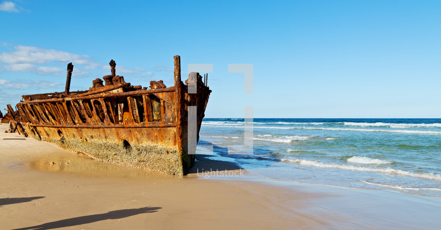 corroded rusty boat on a beach shore 