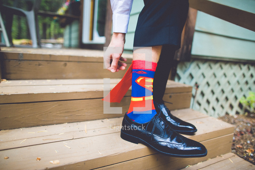 A man wearing Superman socks. 