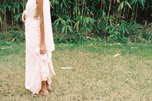 a woman in a long dress standing in grass