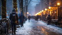 people walking on the city street at night in winter with snowfall