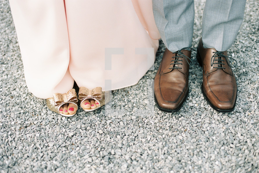 feet of a couple standing together 