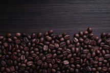 Coffee beans on a dark wooden background. Close up.