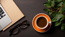 Coffee cup with notebook and glasses on black table background.