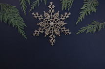 gold snowflake ornament on a black background 