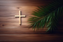 Wooden christian cross with palm leaves on wooden planks background