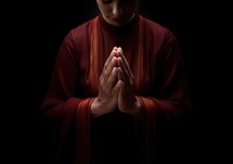 Praying on black background, close-up