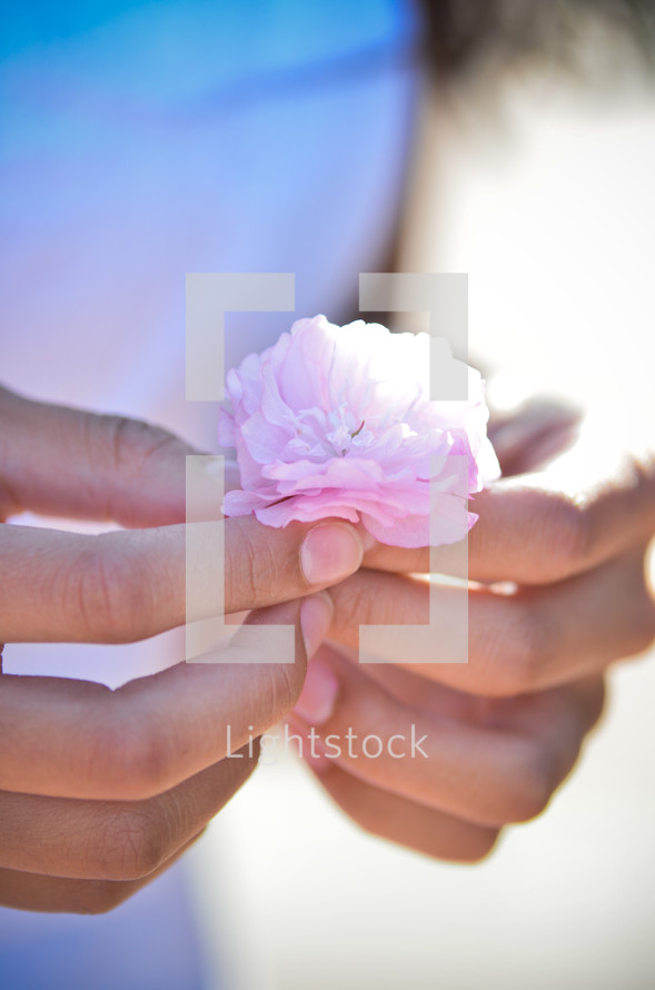 girl holding a pink flower