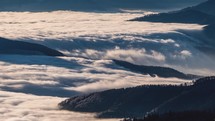 Falls of foggy clouds motion fast over forest mountain in sunny nature landscape Time lapse
