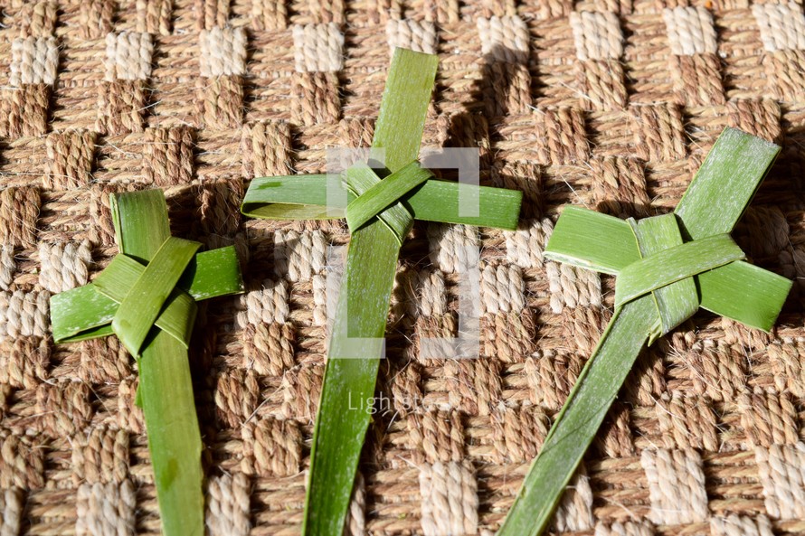 three palm crosses on burlap rug 
