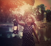 a little girl carrying a lantern with butterflies flying around her 