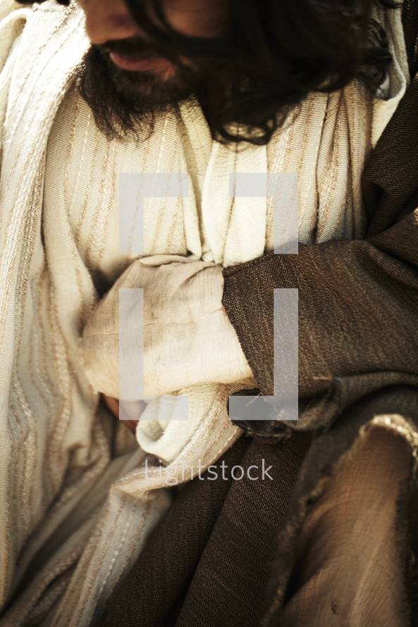 Jesus kneeling down in his robes.