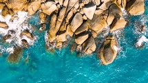 Aerial Top view of a transparent blue sea with beautiful waves. Aerial view seashore cliffs wave crashing on rocks