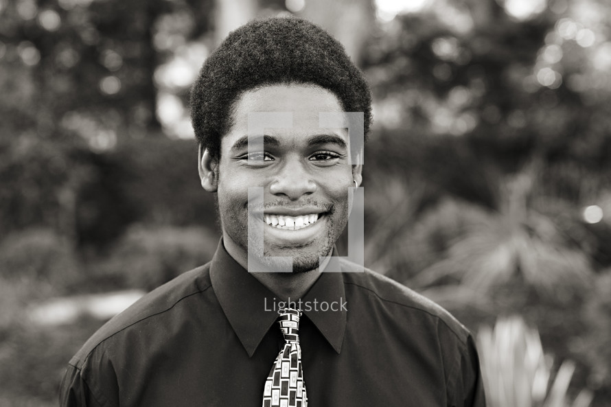 A smiling young man in a shirt and tie black African American 