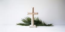 Palm Sunday. Wooden cross with palm leaves on a white background. Copy space.