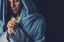Mary in a blue shroud with praying hands 