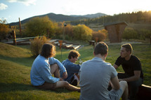 young men sitting outdoors talking 