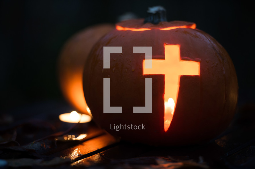 pumpkin carved with cross - candle light