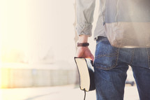 college student holding a Bible at his side 
