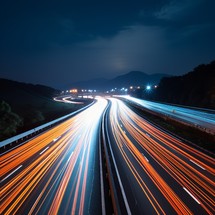 In a long exposure night shot of a highway, blurred lights streak across the frame, crafting a dynamic and energetic atmosphere