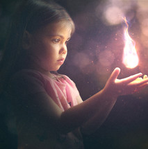 mesmerized child holding a flame 