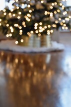 out of focus Christmas tree and reflection on a wood floor 