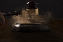 banging gavel with dust.
