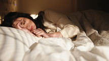 Woman sleeping in bed at early morning