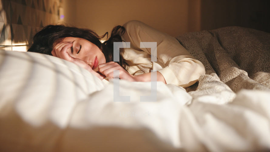 Woman sleeping in bed at early morning