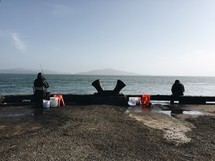 Fishermen on an ocean pier.