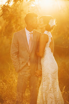 bride and groom kissing outdoors under the glow of the sun