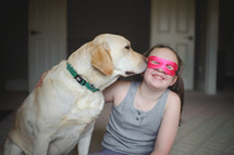 a child in a mask and her dog 