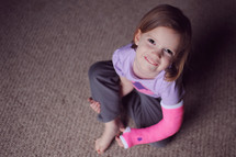 smiling girl child sitting on a floor 