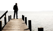 a man standing at the end of a pier 