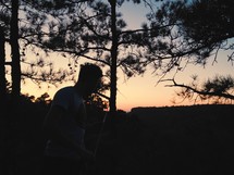 man hiking in a forest at dusk 