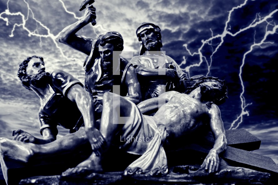 Sculpture of Jesus being nailed to the cross with lightning in the background.