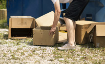 man throwing away old cardboard boxes