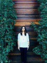 woman standing in front of a wall of wood 