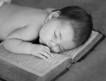 an infant sleeping on a Bible