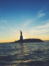 silhouette of the statue of liberty at sunset 