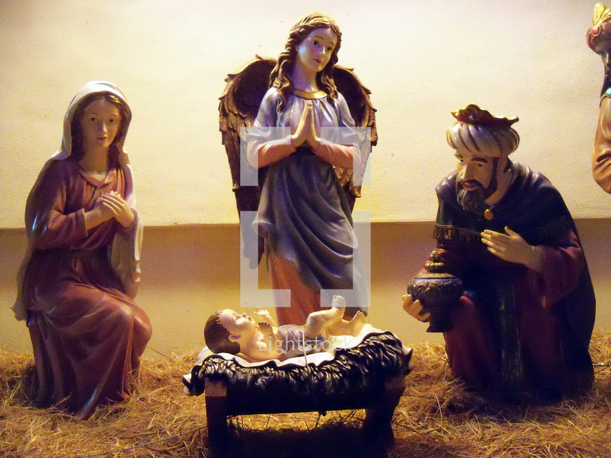 A depiction of the Nativity scene  featuring Baby Jesus, Mary, two of the wise men and an angel adoring Jesus at his birth. 