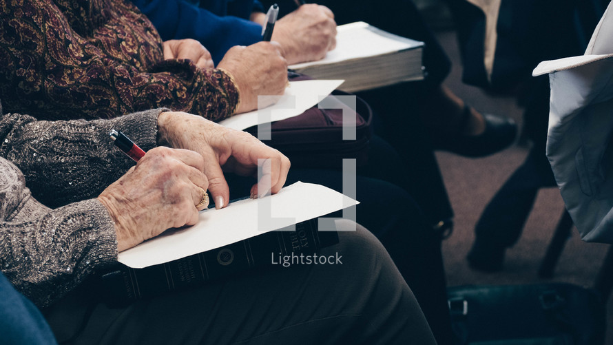 elderly taking notes on Bibles 