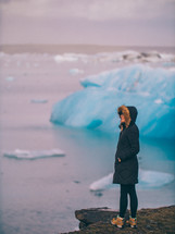 a woman looking at icebergs 