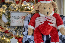 female child holding a Santa Claus Teddy Bear gift for Christmas 