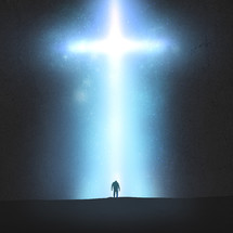 silhouette of a man standing under an illuminated cross