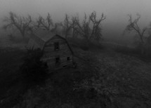 Aerial shot of an old barn on a foggy day.