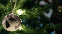 White ball hanging and moving on a christmas tree