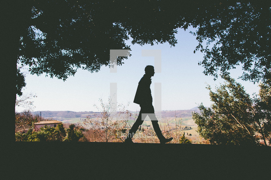 Silhouetted man walking in Tuscany